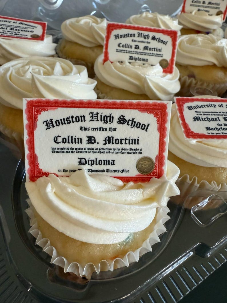 Może przedstawiać: Babeczki z białym lukrem, każda zwieńczona jadalnym obrazkiem w kształcie dyplomu. Na dyplomach widnieje napis "Houston High School" i "Collin D. Mortini". Babeczki znajdują się w przezroczystym plastikowym pojemniku.