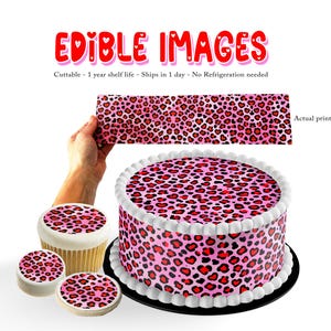May include: A pink cake and cupcakes with a leopard print design featuring red heart shapes. The words "EDIBLE IMAGES" are in red with pink heart accents. A hand holds a strip of the leopard print. The cake has white frosting.