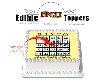 May include: A white cake with a yellow icing sheet featuring a bingo card with the numbers 1, 12, 8, 14, 46, 26, 21, 23, 31, 70, 33, 32, 48, 47, 59, 52, 66, 63, 75, 69. The icing sheet also has the text "BINGO" and "Happy Birthday Delores".