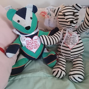 May include: Two handmade teddy bears with striped fabric and hearts sewn on their chests. The hearts have embroidered messages about the shirts they were made from.