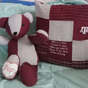 May include: A maroon and white plaid teddy bear with a heart-shaped patch that says "Pap" on one foot. The bear is sitting next to a maroon and white plaid pillow with the letters "ATM" embroidered on it. The pillow also has a message embroidered on it that says "This is a shirt I used to wear, When you hold it Know I am there. Love, Larry."