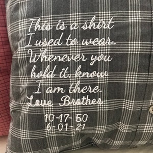 May include: A gray and white plaid pillow with white embroidered text that reads "This is a shirt I used to wear. Whenever you hold it know I am there. Love Brother 10-17-50 6-01-21"
