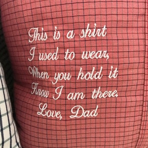 May include: A red and white checkered pillow with white embroidery that reads "This is a shirt I used to wear, When you hold it Know I am there Love, Dad".