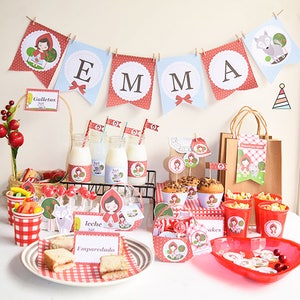 May include: Red and white themed party decorations for a child's birthday party. The decorations include a banner with the name "EMMA", red and white checkered tablecloths, red and white cups, and red and white plates. There are also cupcakes with red frosting and a red and white checkered cupcake liner.