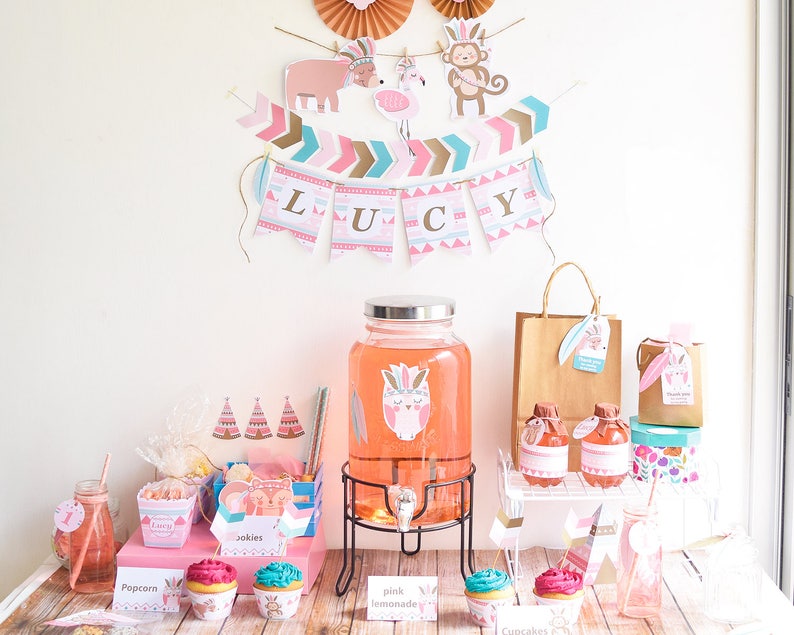 May include: A pink and gold themed party table setting with a pink lemonade dispenser, cupcakes, and party favors. The table is decorated with a banner that says "LUCY" and has a pink owl design.