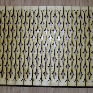 Puede incluir: Un panel de madera con un patr&oacute;n repetitivo de formas de diamante recortadas. El panel es de madera marr&oacute;n claro y los recortes son marr&oacute;n oscuro.