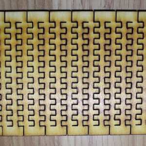 Puede incluir: Primer plano de un rompecabezas de madera con un patr&oacute;n repetitivo de cuadrados entrelazados. El rompecabezas est&aacute; hecho de m&uacute;ltiples piezas que encajan para crear un dise&ntilde;o m&aacute;s grande.