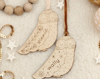 Puede incluir: Dos adornos de búho de madera con nombres personalizados, Winnie y Wally. Los búhos están pintados en un color madera natural y tienen detalles delicados como hojas y estrellas.
