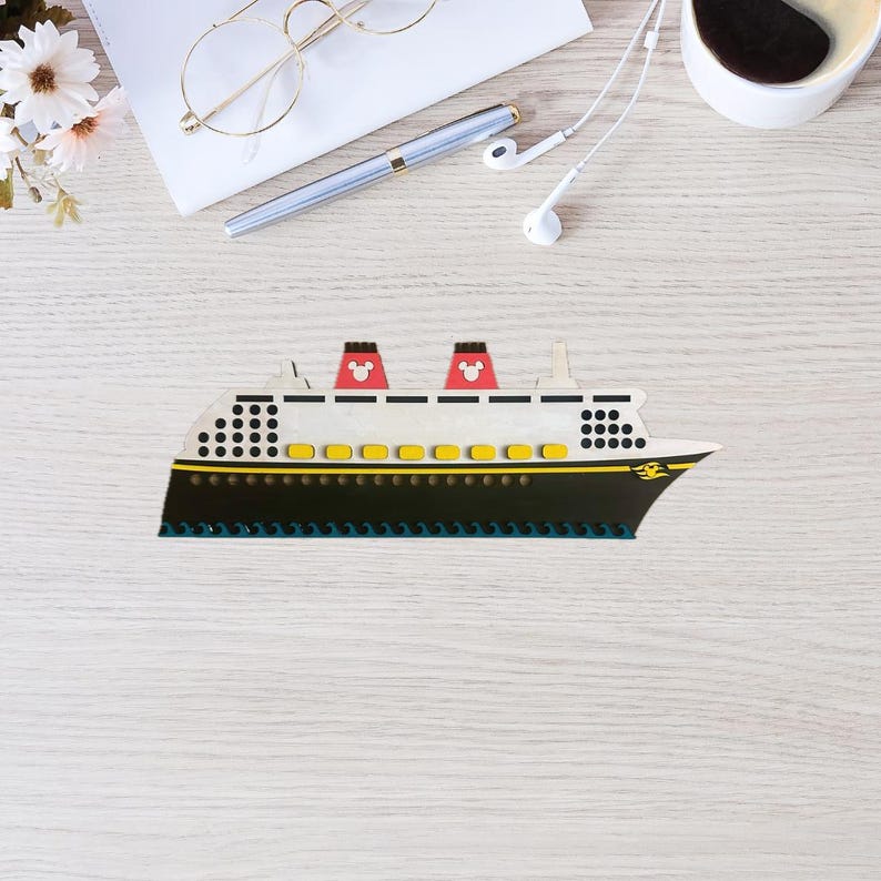 May include: A white and black cruise ship with red Mickey Mouse ears on the top of the ship. The ship has yellow portholes and a black hull.