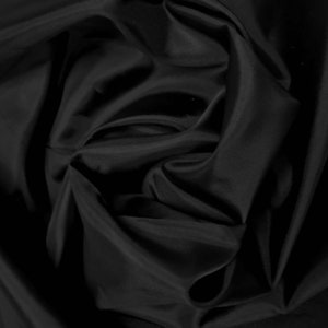 May include: Black fabric with a smooth, silky texture. The fabric is draped and folded, creating soft, flowing curves.