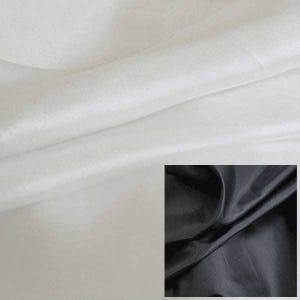 May include: Two swatches of fabric, one white and one black. The white fabric is smooth and silky, while the black fabric is more textured.