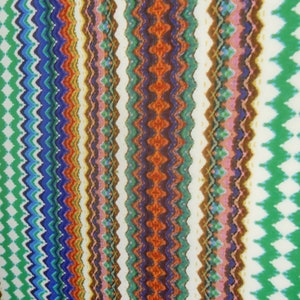 May include: Colorful fabric with a chevron pattern in shades of green, blue, red, orange, brown, and white.