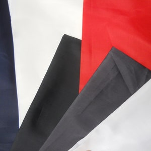 May include: Four fabric swatches in different colors: navy blue, black, dark gray, and red. The swatches are arranged in a fan shape.