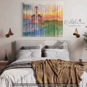 May include: A bedroom interior with a gray headboard and a brown blanket on the bed. A wall hanging with a colorful abstract design is on the wall above the bed. The wall hanging is labeled "Wallflowers Hanging Art".