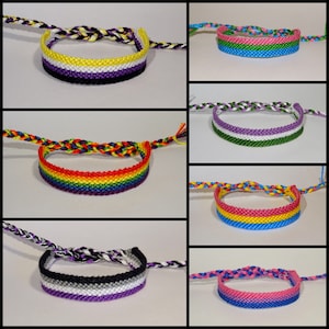 Puede incluir: Seis pulseras de la amistad en varios colores y patrones, incluyendo arcoíris, morado, verde, amarillo, azul y rosa. Las pulseras están hechas con cuerda tejida y están atadas con un nudo al final.