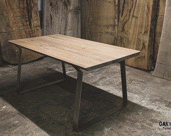 May include: A rectangular wooden table with a light brown surface and a dark gray metal frame. The table has a modern design and is suitable for various uses. The table is approximately 60 inches long and 30 inches wide.