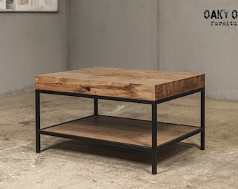May include: A square coffee table with a natural wood top and lower shelf, supported by a black metal frame. The table has a rustic, industrial design. The text "Oaky Oak furniture" is in the upper right corner.