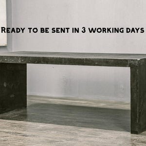 Op de afbeelding: Een donkergrijze rechthoekige tafel met een minimalistisch ontwerp. De tafel heeft een solide, blokkerige constructie met een platte bovenkant en twee steunpoten. De tekst "READY TO BE SENT IN 3 WORKING DAYS" is zichtbaar.