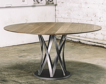 May include: A round dining table with a light wood top and a unique metal base. The table's top is approximately 48 inches in diameter. The base features an intricate design of intersecting metal bars, providing a modern aesthetic.