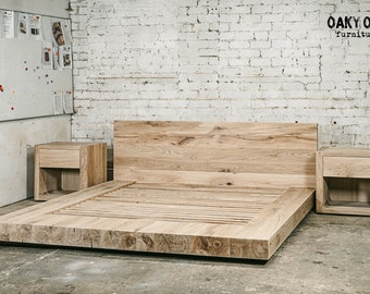 May include: A light-colored wooden bed frame with a headboard and two matching nightstands. The bed frame is low to the ground and has a slatted base. The nightstands have a single drawer. The furniture is made of solid wood.