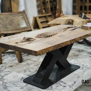 Puede incluir: Mesa de centro rectangular de madera con diseño de cocodrilo tallado. La mesa tiene un acabado de madera natural y una base de metal negro. Un mueble único.