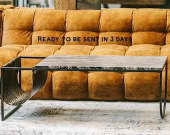 May include: A modern coffee table with a rectangular, textured tabletop and a black metal frame. The table has a unique design with a curved side element. The text "READY TO BE SENT IN 3 DAYS" is visible.