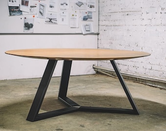May include: A round wooden table with a light brown top and black metal legs. The legs form a geometric design, providing a modern aesthetic. The table is suitable for dining or as a decorative piece.