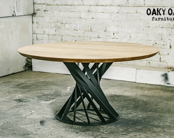 May include: A round wooden table with a light brown finish. The table has a unique base made of black metal, with a twisted, geometric design. The table is a piece of furniture, suitable for dining or other uses. The brand name "Oaky Oak furniture" is visible.