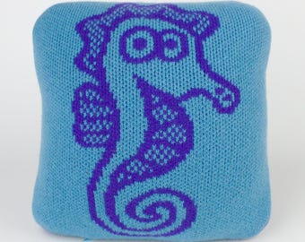 25cm knitted seahorse cushion. Turquoise & purple merino lambswool. Handmade in UK.
