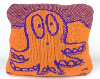 40cm knitted octopus cushion. Orange & purple merino lambswool. Handmade in UK.