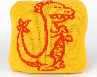 25cm knitted dinosaur cushion. Red & yellow merino lambswool. Handmade in UK.