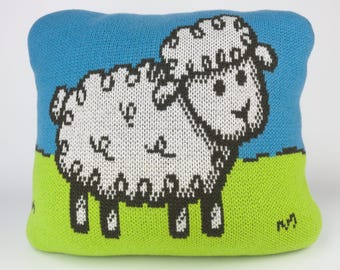 40cm knitted sheep cushion. Grey, white, green & blue merino lambswool. Handmade in UK.