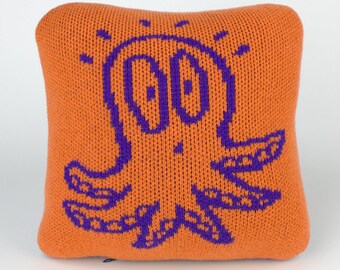 25cm knitted octopus cushion. Orange & purple merino lambswool. Handmade in UK.