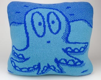40cm knitted octopus cushion. Turquoise & dark blue merino lambswool. Handmade in UK.
