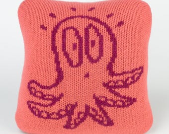 25cm knitted octopus cushion. Coral & reddish purple merino lambswool. Handmade in UK.