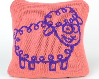 25cm knitted sheep cushion. Coral pink & purple merino lambswool. Handmade in UK.