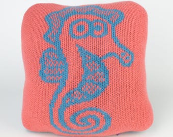 25cm knitted seahorse cushion. Turquoise & coral merino lambswool. Handmade in UK.