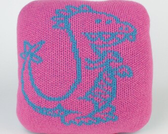 25cm knitted dinosaur cushion. Pink & turquoise merino lambswool. Handmade in UK.