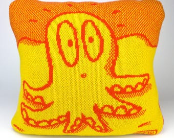 40cm knitted octopus cushion. Red & yellow merino lambswool. Handmade in UK.