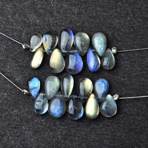 K&ouml;nnte beinhalten: Zwei Str&auml;nge aus irisierenden blauen und gr&uuml;nen Labradorit-Edelsteinen in Tropfenform.