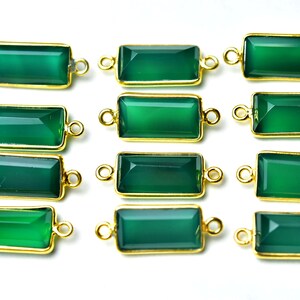 May include: Twelve green gemstone rectangle connectors with gold-toned metal accents. Each connector has two loops for attaching to jewelry.