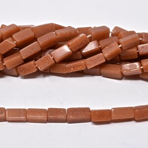 May include: A strand of brown rectangular gemstone beads. The beads are smooth and have a slightly glittery finish.