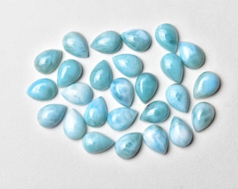 May include: A collection of 25 teardrop-shaped, light blue and white cabochon gemstones. The stones have a cloudy, marbled appearance.