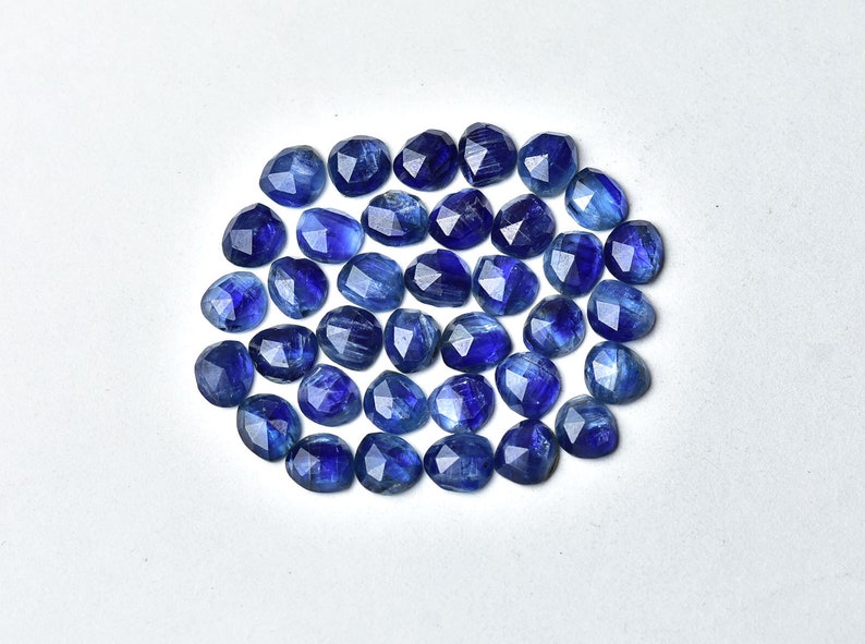 May include: A collection of 30 faceted blue kyanite gemstone beads. The beads are oval shaped and have a smooth, polished finish.