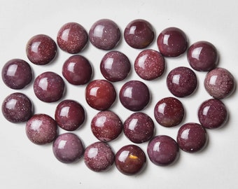 May include: A collection of 25 round, polished, red gemstone cabochons with a speckled, glittery texture.