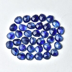 May include: A collection of 30 faceted blue kyanite gemstone beads. The beads are oval shaped and have a smooth, polished finish.