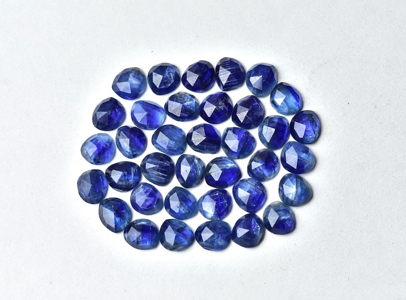 May include: A collection of 30 faceted blue kyanite gemstone beads. The beads are oval shaped and have a smooth, polished finish.