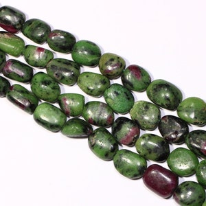May include: A strand of green and pink gemstone beads. The beads are oval shaped and have a smooth, polished finish.