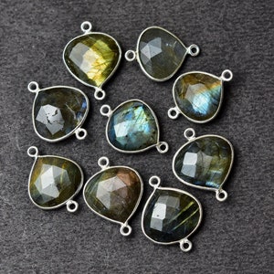 May include: Ten silver-toned gemstone connector charms with a teardrop shape. The gemstones are iridescent labradorite with shades of green, blue, and gold.
