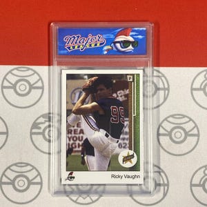 Puede incluir: Una tarjeta de béisbol con un jugador de béisbol con un uniforme rojo, blanco y azul. El jugador está lanzando una pelota de béisbol. La tarjeta está titulada "Ricky Vaughn" y tiene un logotipo de "Rookie". La tarjeta está en una funda protectora de plástico.